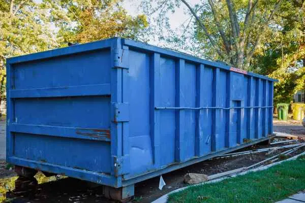 close up of blue dumpster in a residential area