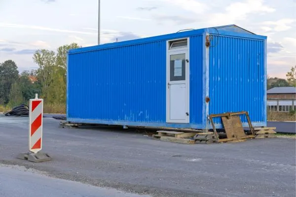 blue storage container used as temporary office on job site