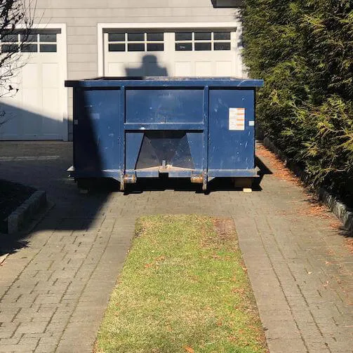 Roll off dumpster in front of home garage