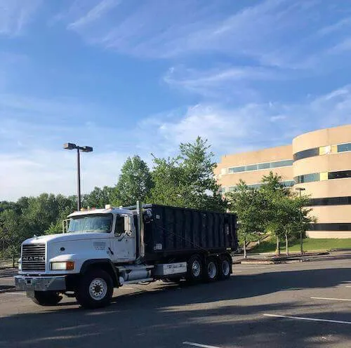 Roll-off truck and dumpster in a commercial parking lot in Northampton County PA