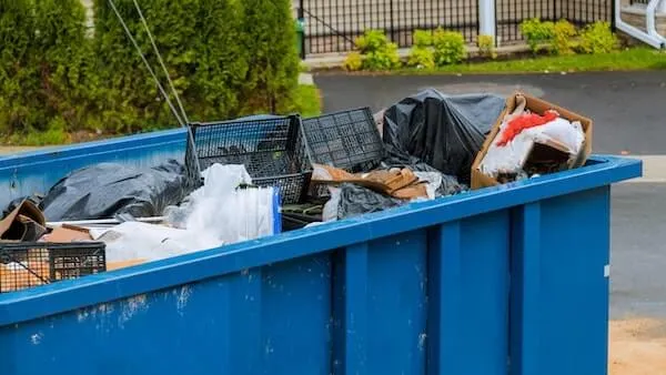 Picture of a blue dumpster filled with trash 