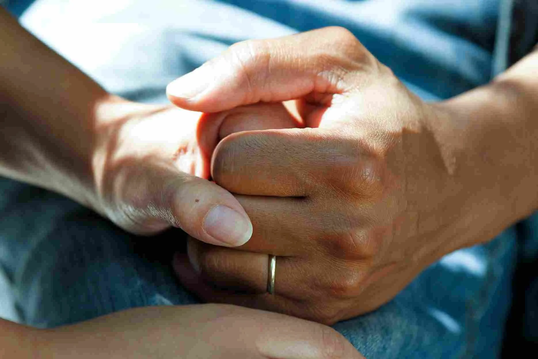 A close up of two people holding hands 